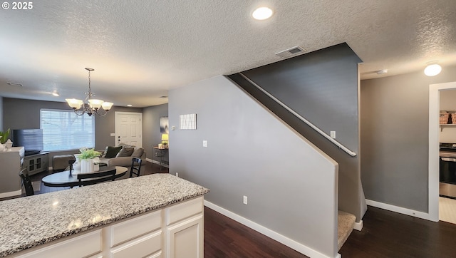 kitchen featuring dark wood-style floors, range, visible vents, and light stone countertops