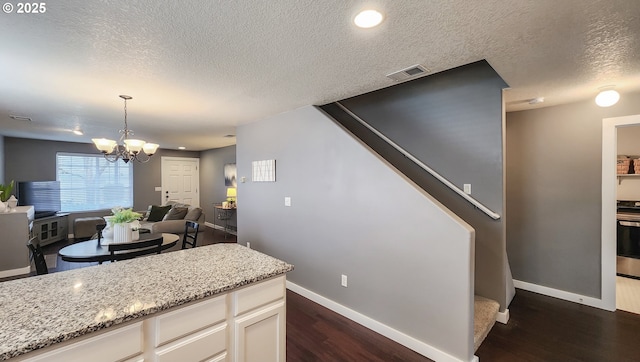 15340 SW Lexington Ln, Beaverton, OR 97007 - kitchen with dark wood finished floors, baseboards, a textured ceiling, a chandelier, and light stone counters