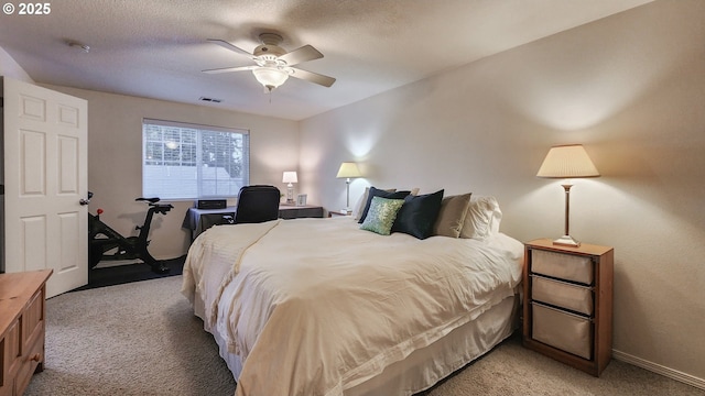 bedroom featuring baseboards, visible vents, a ceiling fan, light colored carpet, and a textured ceiling