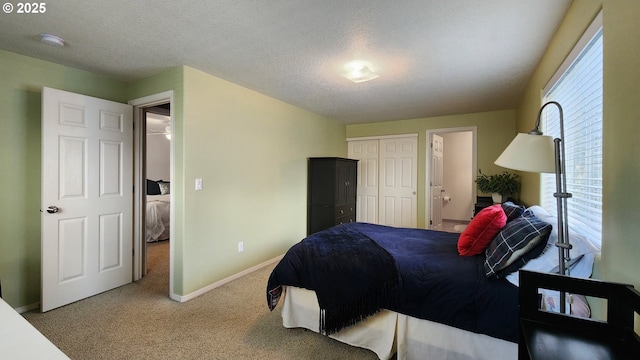 carpeted bedroom featuring a textured ceiling, a closet, and baseboards