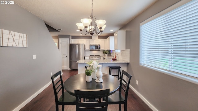 dining room with an inviting chandelier, baseboards, and dark wood-type flooring