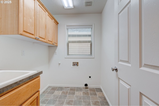 clothes washing area with gas dryer hookup, cabinets, a textured ceiling, hookup for a washing machine, and electric dryer hookup