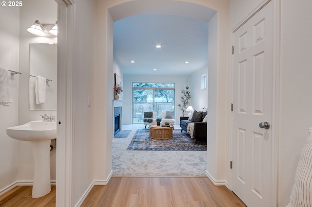 hallway with sink and light hardwood / wood-style floors