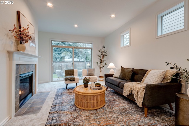 carpeted living room featuring a tile fireplace