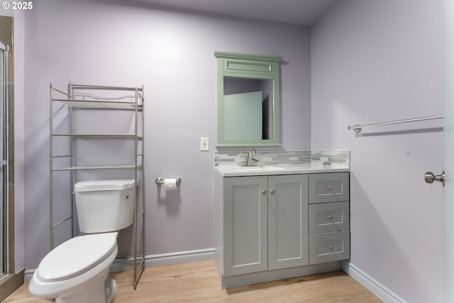 full bathroom with tasteful backsplash, toilet, vanity, wood finished floors, and baseboards