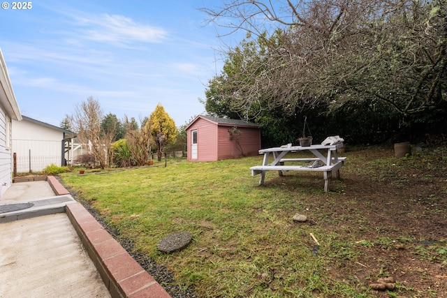 view of yard with an outbuilding, fence, and a storage unit