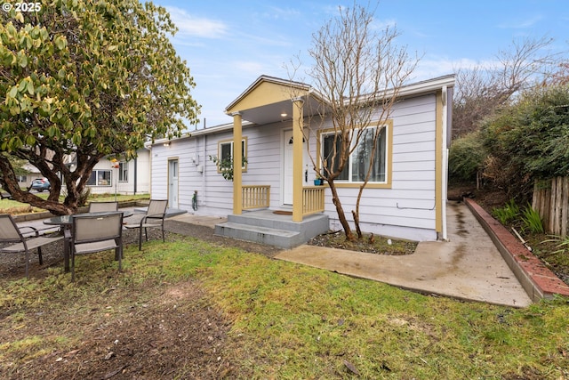 rear view of property with a yard and fence