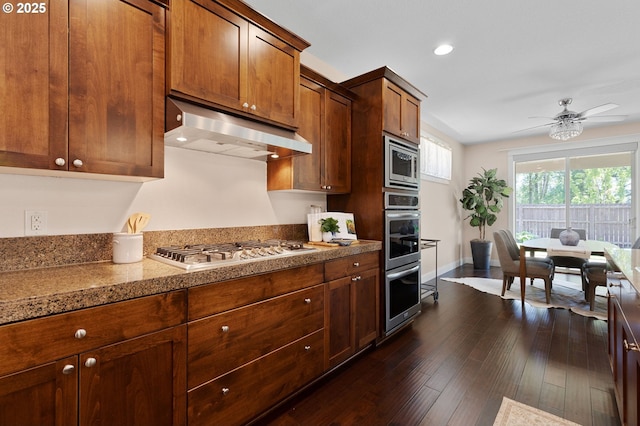 14609 NE 112th St, Vancouver, WA 98682 - kitchen featuring under cabinet range hood, appliances with stainless steel finishes, a ceiling fan, dark wood-style flooring, and baseboards