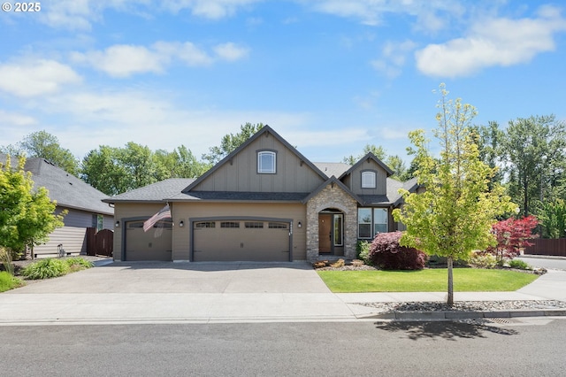 14609 NE 112th St, Vancouver, WA 98682 - view of front facade featuring board and batten siding, an attached garage, driveway, a front lawn, and stone siding