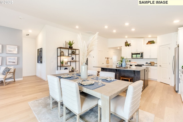 dining room with recessed lighting, baseboards, lofted ceiling, and light wood finished floors