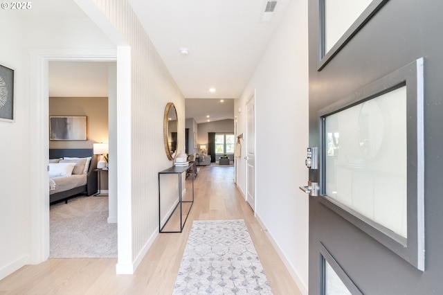 foyer with light wood finished floors, recessed lighting, visible vents, and baseboards