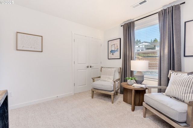 sitting room with visible vents, light carpet, and baseboards