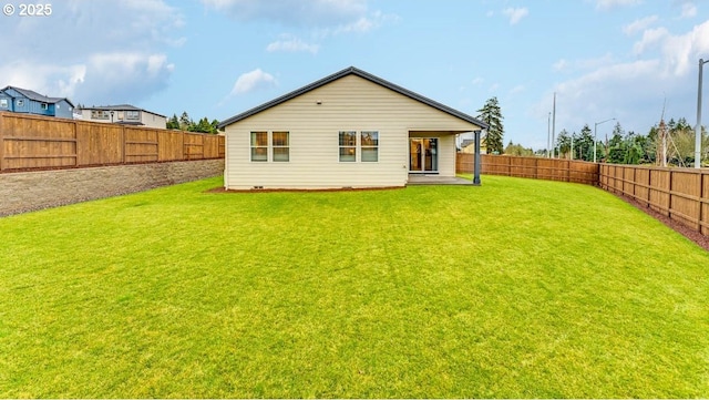 back of house featuring a fenced backyard and a lawn