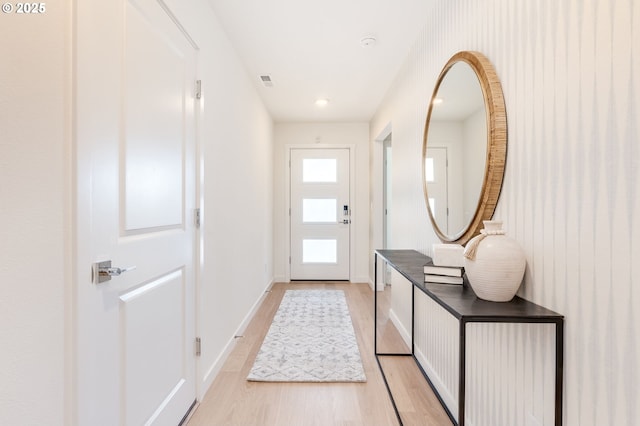 doorway to outside featuring light wood finished floors, visible vents, and baseboards