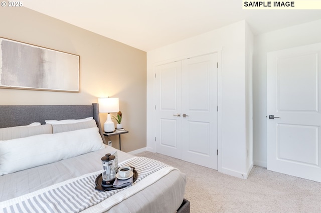 carpeted bedroom featuring baseboards and a closet