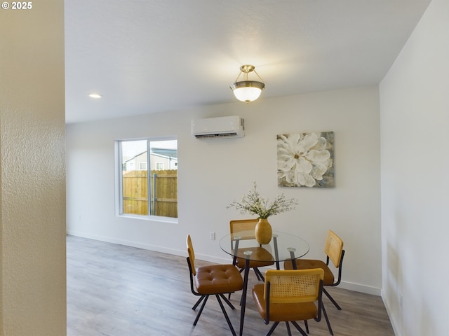 dining room with an AC wall unit and wood-type flooring