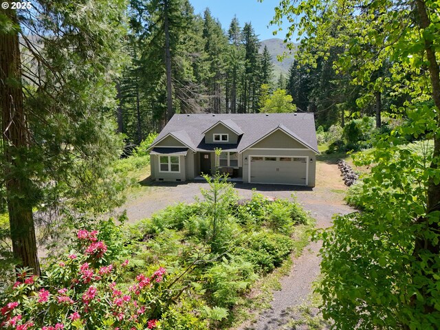51013 Mckenzie Hwy, Vida, OR 97488 - view of front facade featuring driveway, a garage, and a wooded view