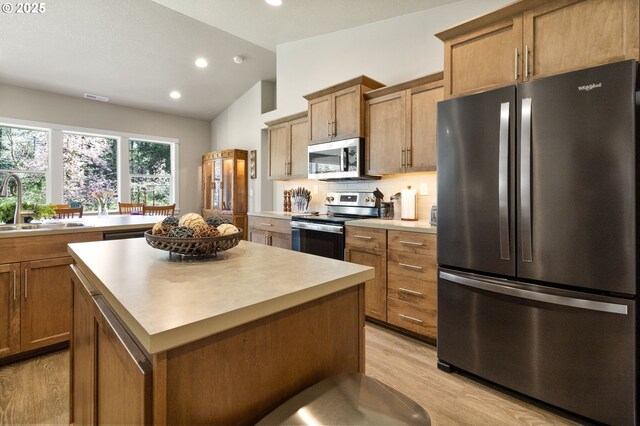 51013 Mckenzie Hwy, Vida, OR 97488 - kitchen with stainless steel appliances, a sink, a kitchen island, lofted ceiling, and light wood-style flooring