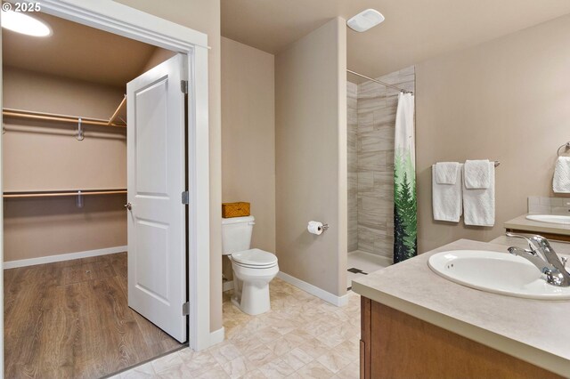51013 Mckenzie Hwy, Vida, OR 97488 - bathroom featuring vanity, tiled shower, toilet, a spacious closet, and baseboards