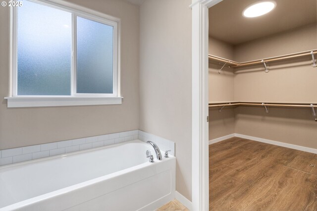 51013 Mckenzie Hwy, Vida, OR 97488 - full bathroom with a garden tub, a walk in closet, wood finished floors, and baseboards