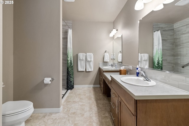 bathroom with baseboards, toilet, vanity, and curtained shower
