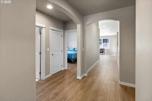 51013 Mckenzie Hwy, Vida, OR 97488 - hall with arched walkways, wood finished floors, baseboards, and recessed lighting