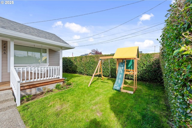 view of yard featuring fence, a porch, and a playground