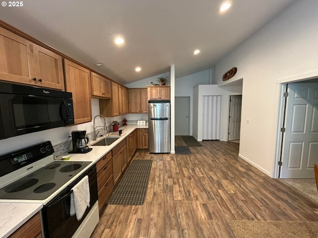 kitchen with a sink, freestanding refrigerator, electric range, lofted ceiling, and black microwave