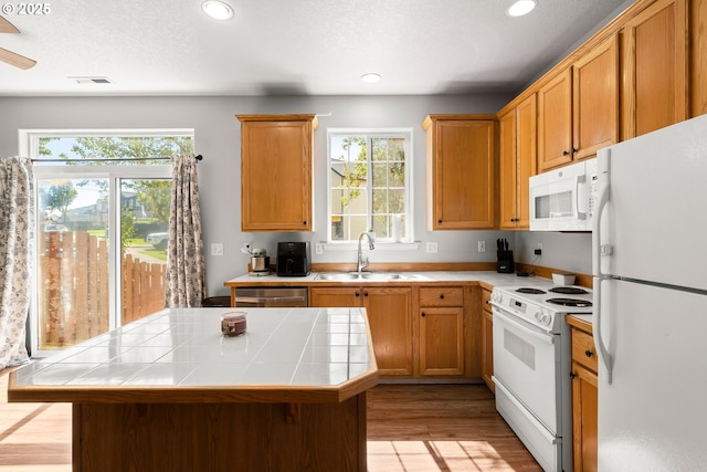 5908 SE 15th Dr, Gresham, OR 97080 - kitchen featuring white appliances, a sink, tile counters, plenty of natural light, and recessed lighting