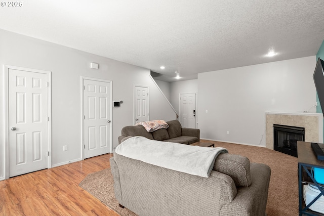 5908 SE 15th Dr, Gresham, OR 97080 - living area with light wood-style flooring, stairway, a textured ceiling, a tiled fireplace, and baseboards