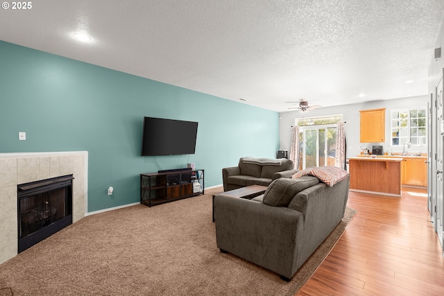 5908 SE 15th Dr, Gresham, OR 97080 - living area featuring healthy amount of natural light, a textured ceiling, a tiled fireplace, recessed lighting, and baseboards