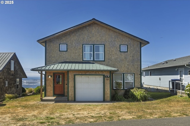 962 SW Waziyata Ave, Waldport, OR 97394 - view of front of house with a standing seam roof, a garage, a front lawn, and a water view