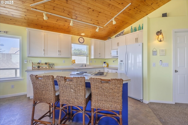 962 SW Waziyata Ave, Waldport, OR 97394 - kitchen featuring white appliances, track lighting, wood ceiling, vaulted ceiling, and white cabinetry