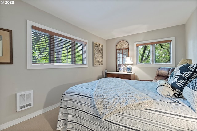 carpeted bedroom featuring baseboards, multiple windows, and visible vents