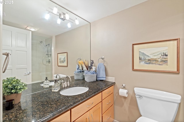 full bathroom with vanity, a tile shower, and toilet