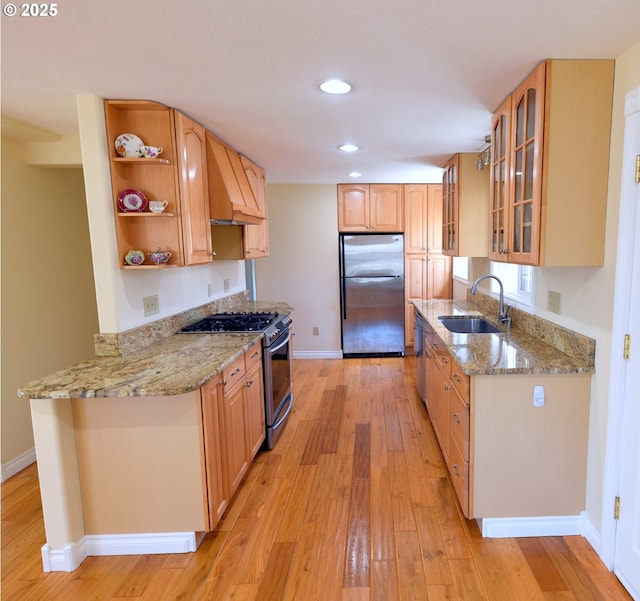 2525 Pine St, Seaside, OR 97138 - kitchen featuring stainless steel appliances, a sink, open shelves, baseboards, and light wood-style floors