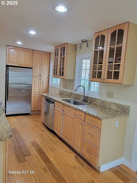 2525 Pine St, Seaside, OR 97138 - kitchen with appliances with stainless steel finishes, a sink, light wood finished floors, light stone countertops, and healthy amount of natural light