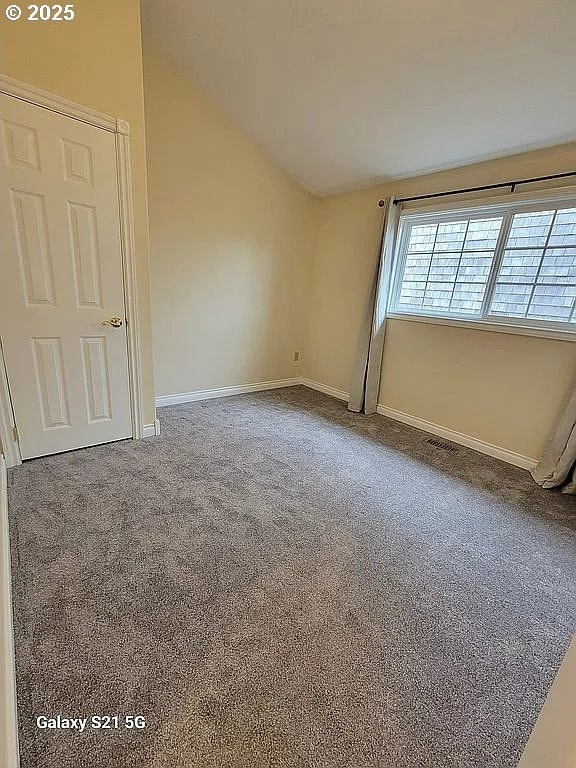 2525 Pine St, Seaside, OR 97138 - carpeted empty room with lofted ceiling and baseboards