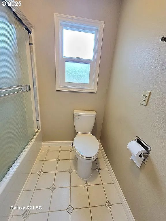 2525 Pine St, Seaside, OR 97138 - bathroom with toilet, baseboards, and combined bath / shower with glass door