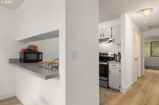 kitchen featuring baseboard heating, under cabinet range hood, white cabinetry, black microwave, and stainless steel range with electric cooktop