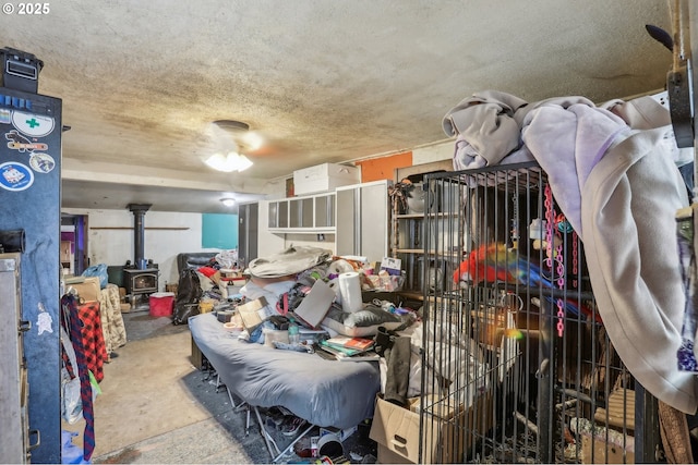 miscellaneous room featuring a textured ceiling and a wood stove