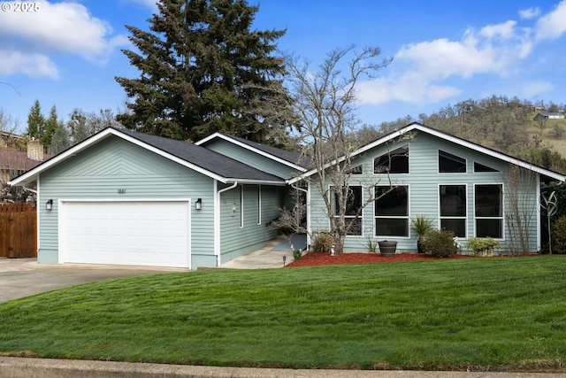 view of front facade featuring a front yard, an attached garage, fence, and concrete driveway