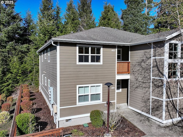 view of front facade featuring a shingled roof and crawl space