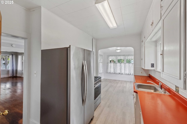 2479 Sherman Ave, North Bend, OR 97459 - kitchen featuring appliances with stainless steel finishes, a sink, arched walkways, light wood-style floors, and healthy amount of natural light