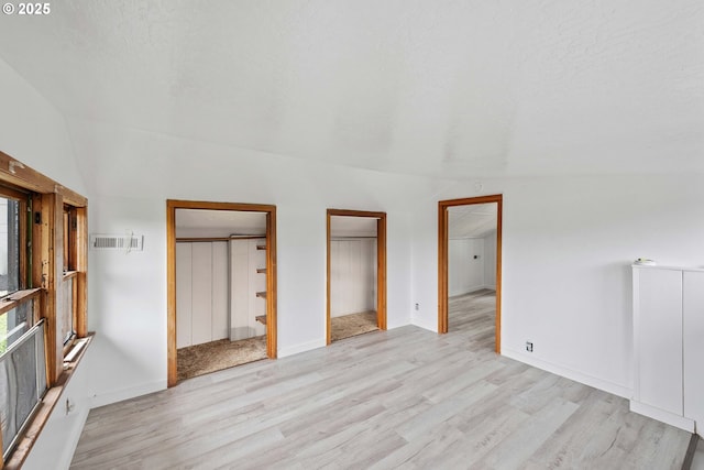 2479 Sherman Ave, North Bend, OR 97459 - unfurnished bedroom with light wood finished floors, lofted ceiling, baseboards, ensuite bathroom, and a spacious closet