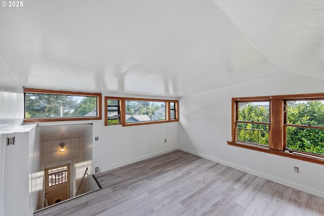 2479 Sherman Ave, North Bend, OR 97459 - unfurnished living room with light wood finished floors, healthy amount of natural light, lofted ceiling, and baseboards