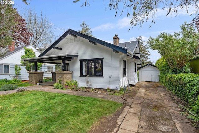 2479 Sherman Ave, North Bend, OR 97459 - view of front of house with a shed, driveway, a chimney, an outdoor structure, and a front yard