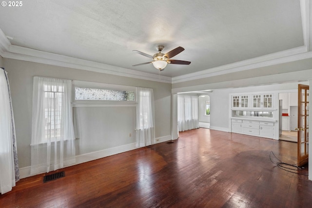 2479 Sherman Ave, North Bend, OR 97459 - unfurnished living room featuring ceiling fan, wood finished floors, baseboards, ornamental molding, and arched walkways