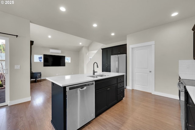 kitchen with recessed lighting, stainless steel appliances, a sink, light wood-style floors, and light countertops