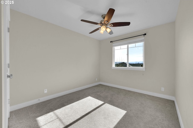 carpeted empty room with baseboards and a ceiling fan